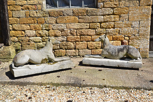 A large pair of composition stone reclining greyhounds by Austin and Seeley