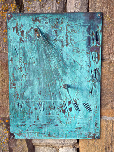 A modern Verdigris wall-mounted brass sundial plate with diagonal indicator