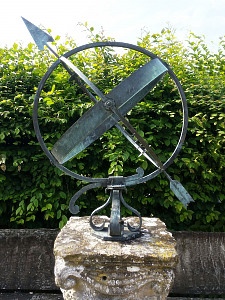A mid- century brass armillary sphere raised upon a scroll base