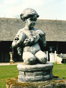 A very attractive 18th Century lead statue depicting a kneeling girl holding a garland of flowers