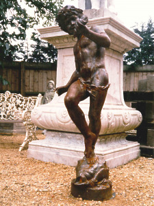 A 19th Century cast iron statue depicting a dancing boy holding a conch shell