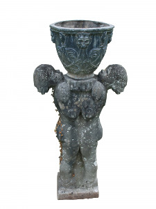A lead urn with stylized foliage decoration supported by a composition stone pedestal in the form of two children