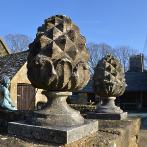 A pair of carved Bath stone pineapple finials