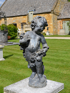 An early 20th century lead garden figure in the form of a cherub