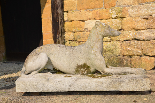 A large pair of composition stone reclining greyhounds by Austin and Seeley