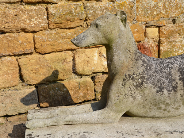 A large pair of composition stone reclining greyhounds by Austin and Seeley