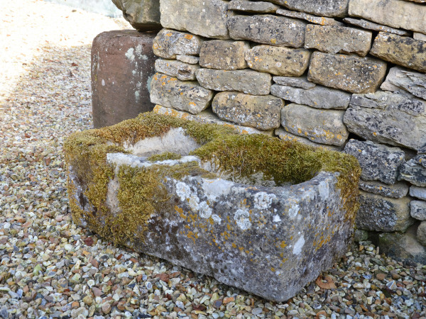 An antique limestone trough with good weathering and patination