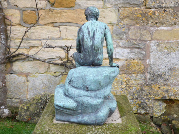 A Neapolitan verdigris bronze of the seated Mercury on a stylised rock