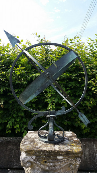 A mid- century brass armillary sphere raised upon a scroll base