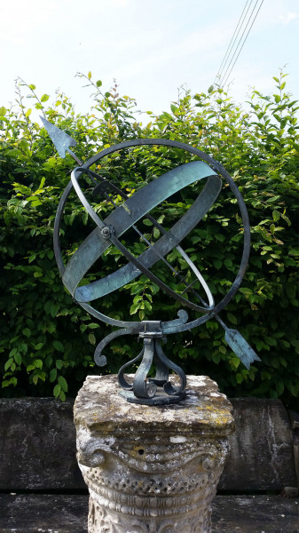 A mid- century brass armillary sphere raised upon a scroll base