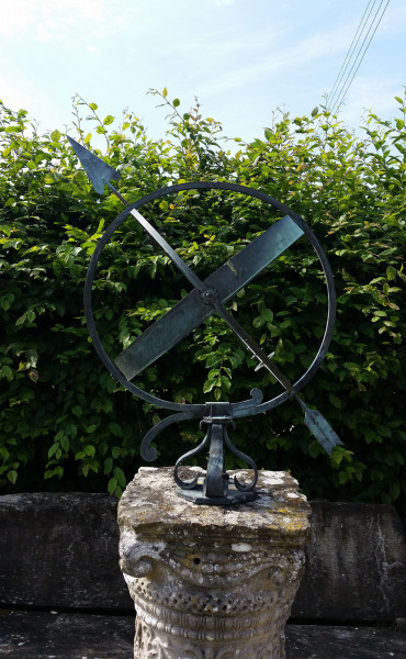 A mid- century brass armillary sphere raised upon a scroll base