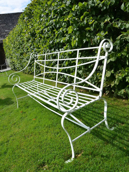 A 19th century wrought iron strap work garden seat having cabriole legs and scroll arms