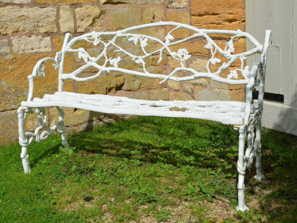 A 19th century cast iron garden seat of a twig and foliage design
