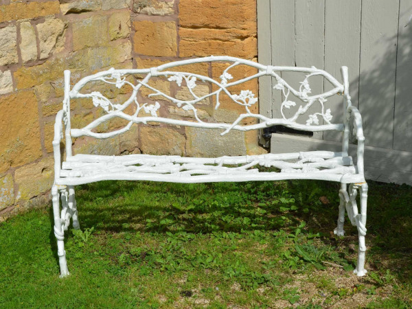 A 19th century cast iron garden seat of a twig and foliage design