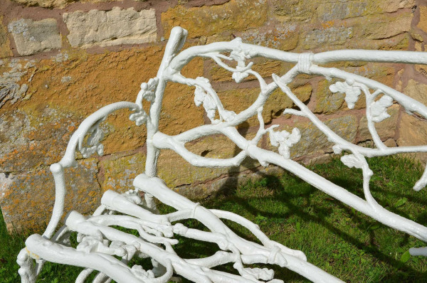 A 19th century cast iron garden seat of a twig and foliage design