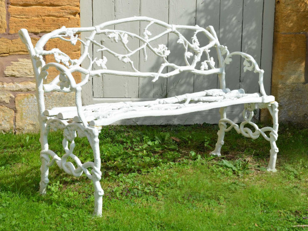 A 19th century cast iron garden seat of a twig and foliage design
