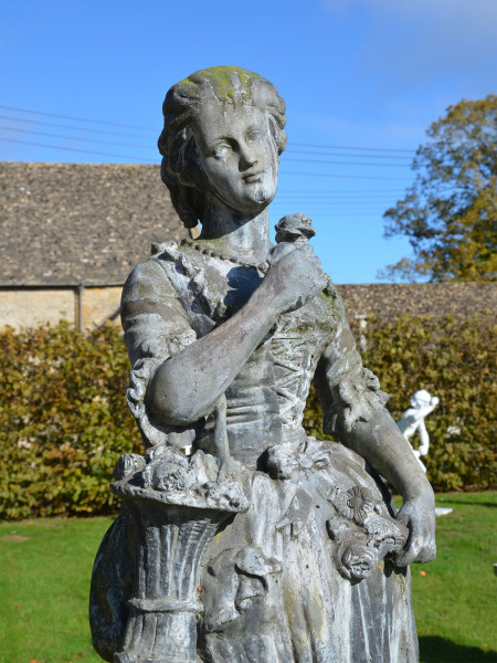 A large lead figure depicting a flower girl 
