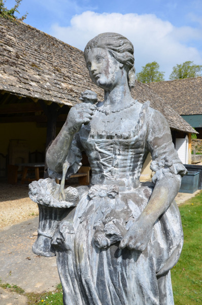 A large lead figure depicting a flower girl 