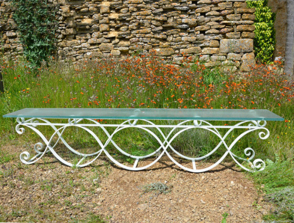 A 20th century iron bench with frosted glass seat