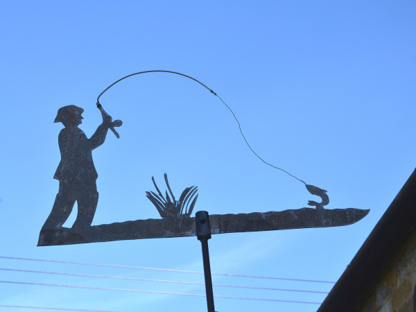 A vintage cut zinc weathervane of a fisherman in action!