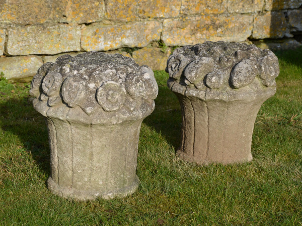 A pair of carved Portland stone fruit and flower baskets