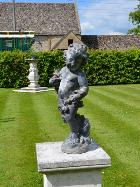An early 20th century lead garden figure in the form of a cherub