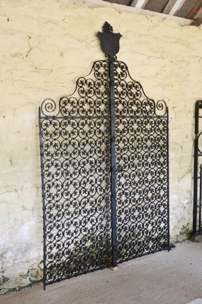 A pair of early 20th century wrought iron garden gates with shield