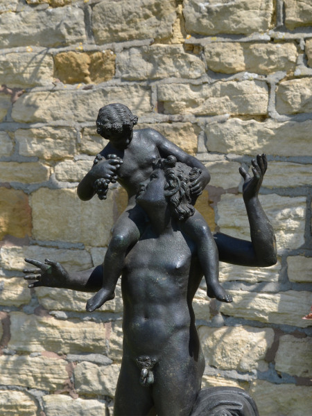 A Neapolitan verdigris bronze model of a young Satyr with the infant Dionysus
